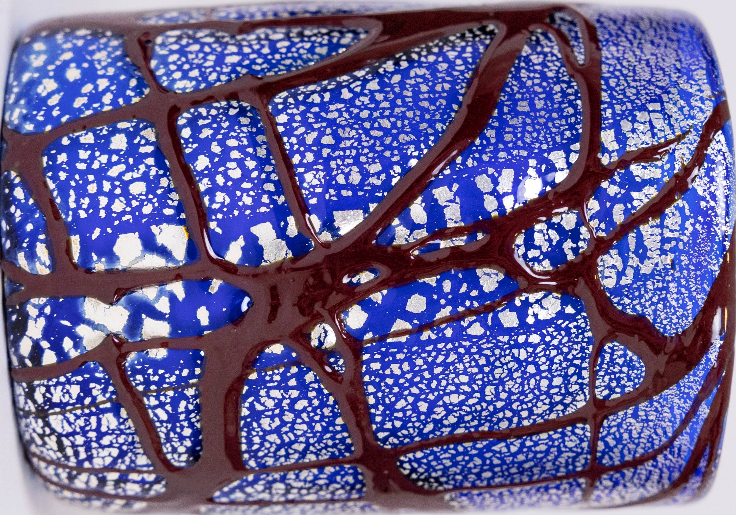 Detailed close up shot of 1889 glass, showing pure silver leaf detail, bordeaux enamel and deep blue hand-blown glass.