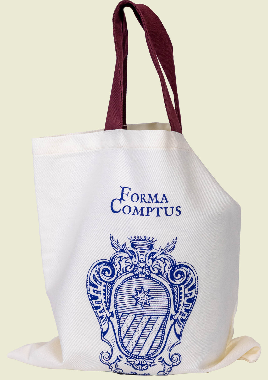 Beige, clear cotton tote bag with blue 'Forma Comptus' design, logo and bordeaux handles